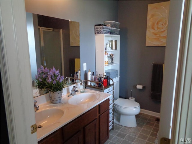 bathroom with toilet, a shower with door, and vanity