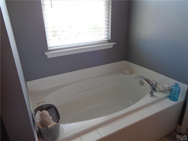 bathroom with a relaxing tiled tub