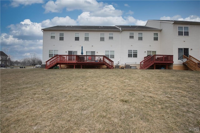 rear view of property with a deck and a yard