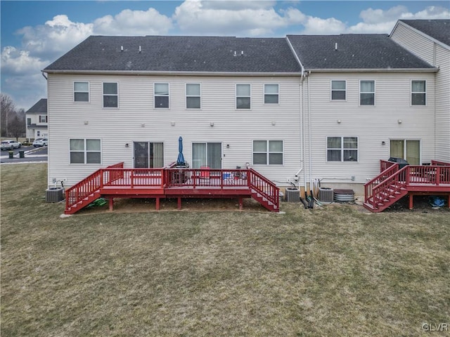 rear view of property featuring a lawn and central AC