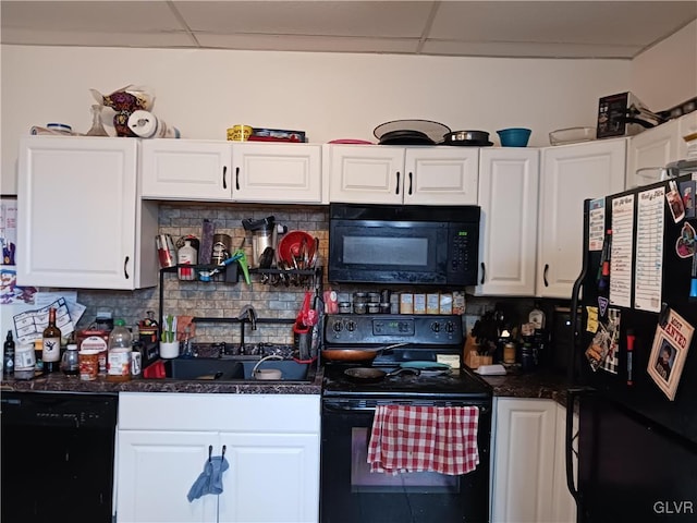 kitchen with white cabinetry, a drop ceiling, black appliances, and tasteful backsplash