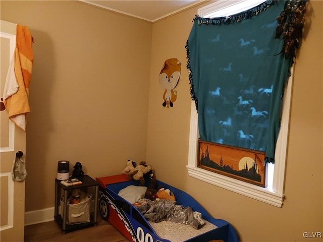 bedroom featuring ornamental molding and wood-type flooring