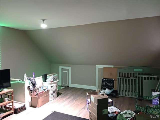 additional living space featuring wood-type flooring and vaulted ceiling