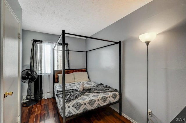 bedroom featuring dark wood-type flooring and a textured ceiling