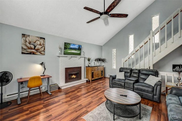 living room with ceiling fan, a fireplace, dark hardwood / wood-style flooring, and high vaulted ceiling