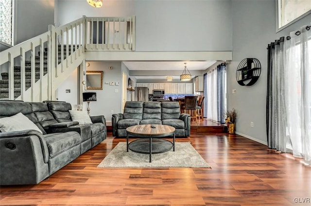 living room featuring a high ceiling and wood-type flooring