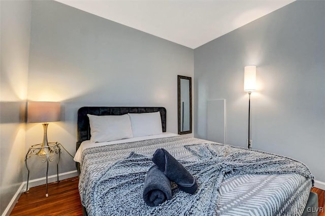 bedroom with dark hardwood / wood-style flooring