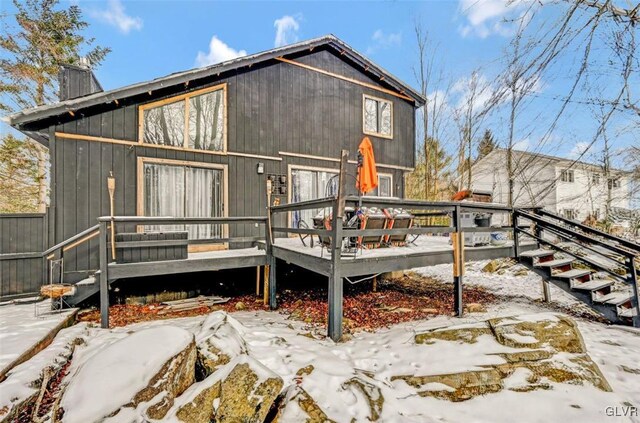 snow covered property with a wooden deck