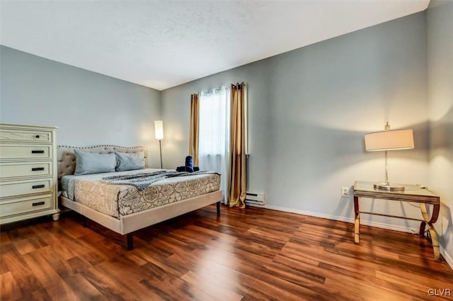 bedroom with a textured ceiling, hardwood / wood-style floors, and a baseboard radiator