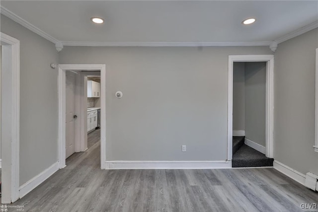 empty room featuring light hardwood / wood-style floors and ornamental molding