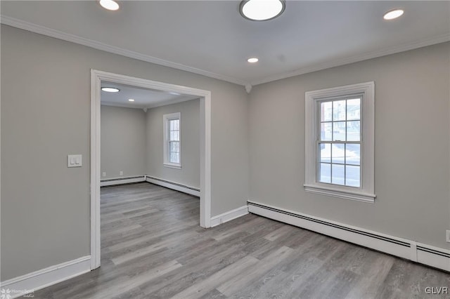 unfurnished room with baseboard heating, crown molding, and light hardwood / wood-style floors