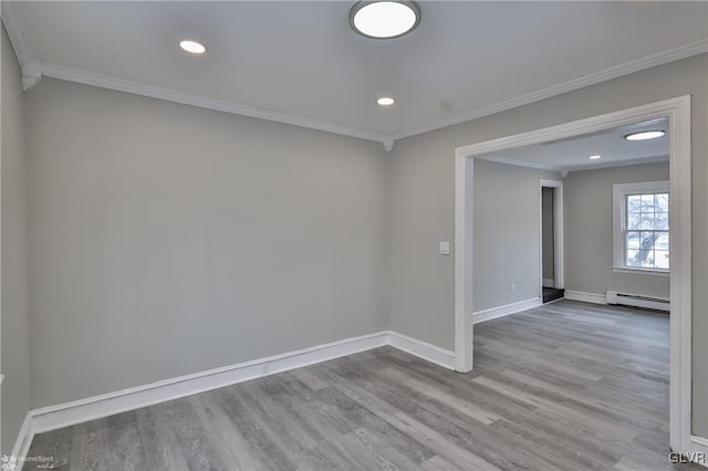 empty room with light wood-type flooring, baseboard heating, and crown molding