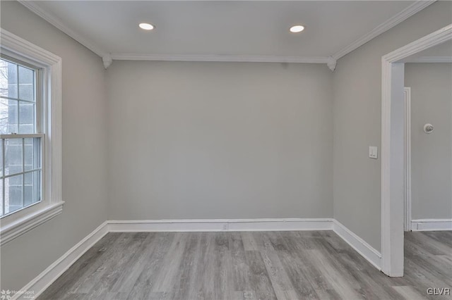 empty room with crown molding and light hardwood / wood-style flooring