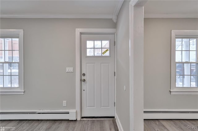 foyer entrance with light wood-type flooring, crown molding, and a baseboard radiator