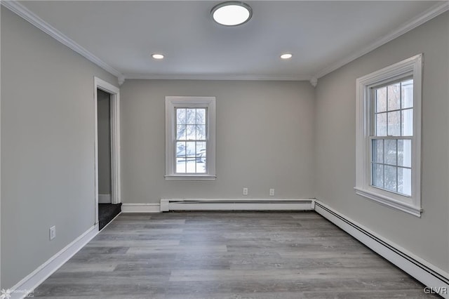 unfurnished room with baseboard heating, ornamental molding, and light hardwood / wood-style flooring