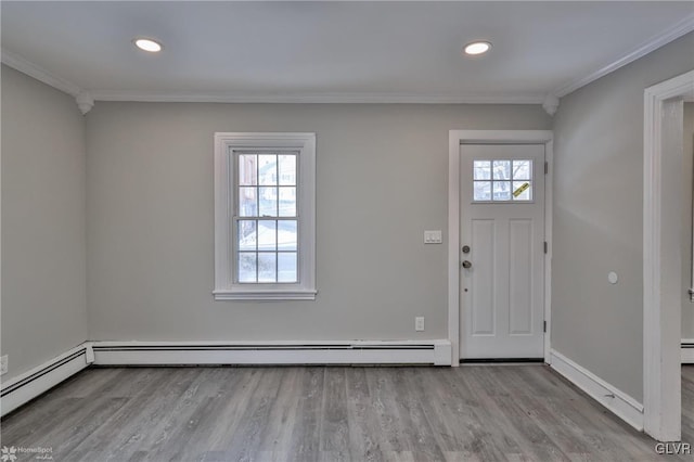 foyer entrance featuring light hardwood / wood-style floors, a baseboard heating unit, and crown molding