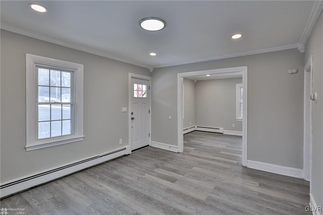 entrance foyer featuring baseboard heating, light hardwood / wood-style flooring, and crown molding