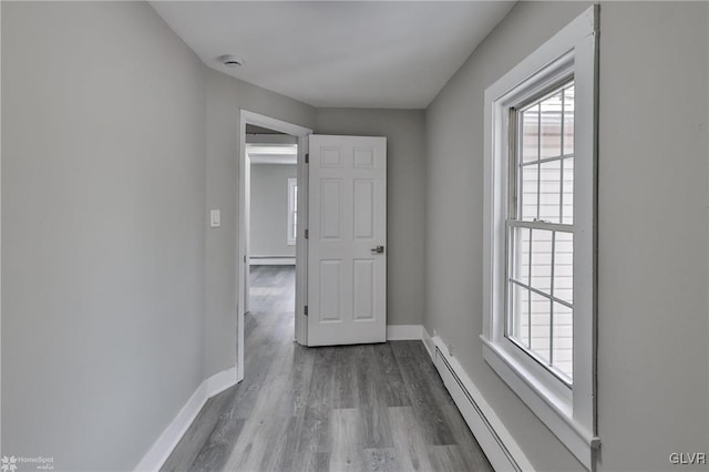 corridor featuring hardwood / wood-style floors and a baseboard radiator