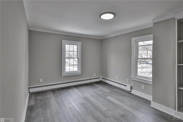 empty room with baseboard heating and wood-type flooring