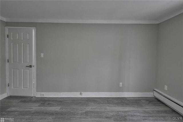 unfurnished room with a baseboard heating unit, crown molding, and hardwood / wood-style flooring