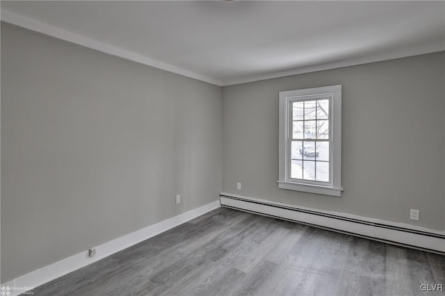 empty room with crown molding, hardwood / wood-style flooring, and a baseboard radiator