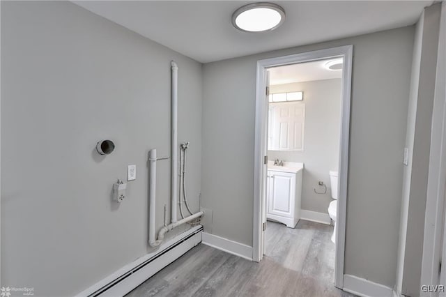 bathroom featuring baseboard heating, hardwood / wood-style floors, toilet, and vanity