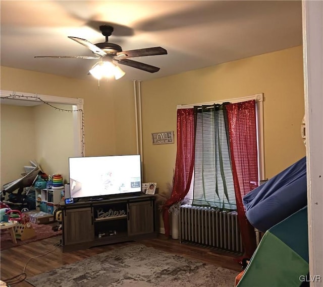 interior space with ceiling fan, hardwood / wood-style floors, and radiator heating unit