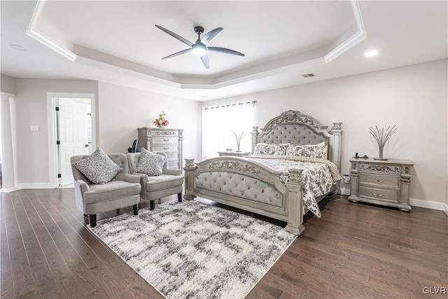 bedroom featuring a raised ceiling, ceiling fan, and dark hardwood / wood-style floors