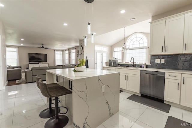 kitchen with white cabinetry, lofted ceiling, pendant lighting, stainless steel dishwasher, and a center island