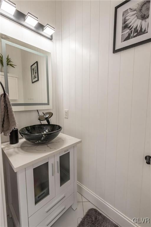 bathroom with vanity, tile patterned flooring, and wood walls