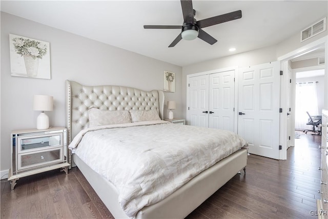 bedroom with dark wood-type flooring, ceiling fan, and a closet