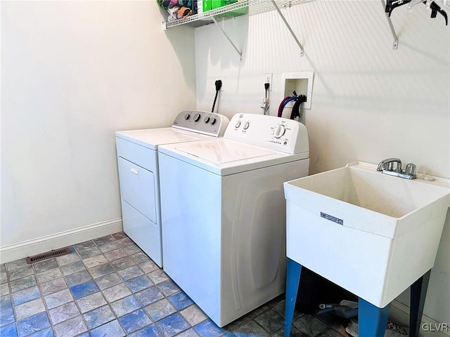 clothes washing area with washer and clothes dryer and sink