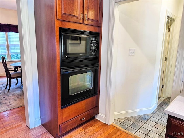 kitchen featuring light hardwood / wood-style floors and black appliances