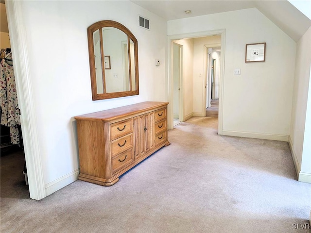 corridor featuring light colored carpet and lofted ceiling