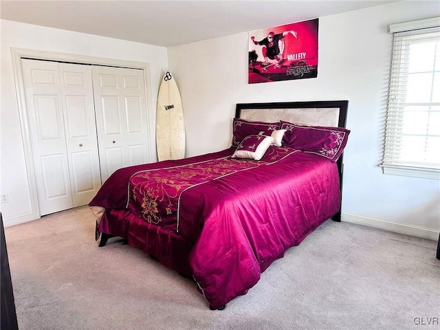 bedroom featuring light colored carpet and a closet