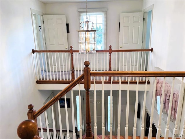 stairway featuring an inviting chandelier