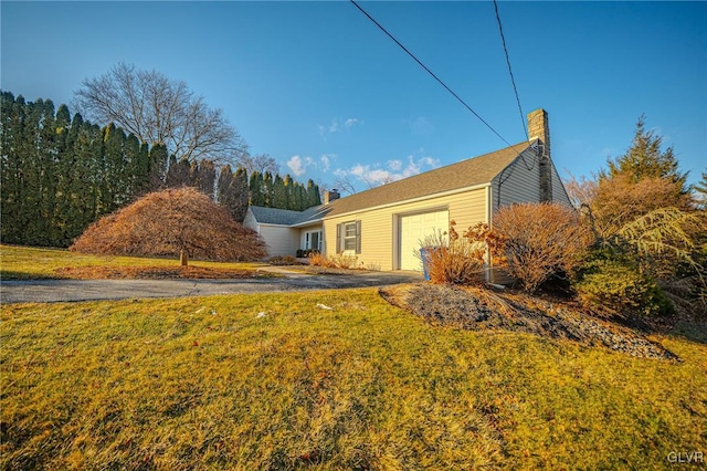 view of side of property with a garage and a yard