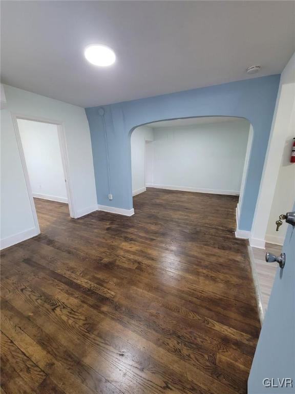 unfurnished room with dark hardwood / wood-style flooring