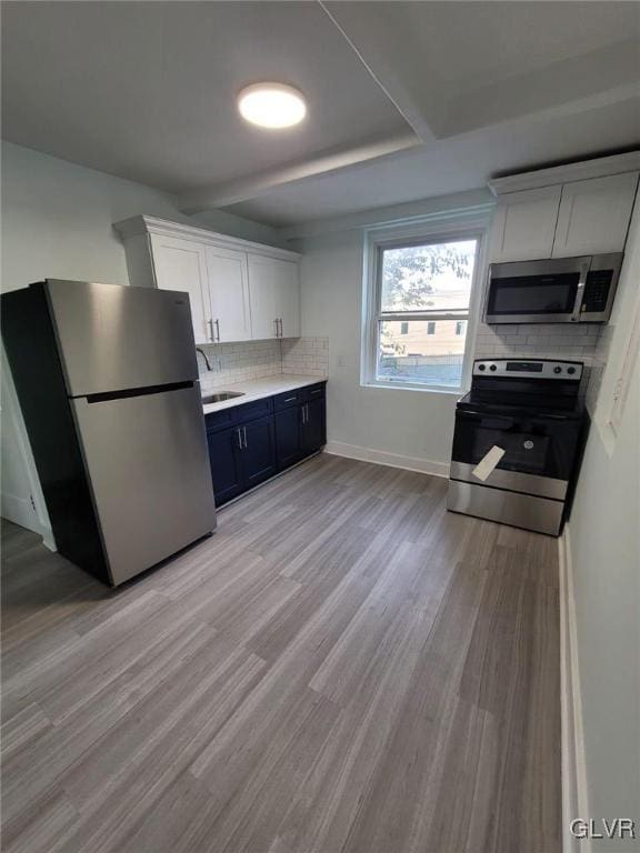 kitchen featuring white cabinets, sink, stainless steel appliances, and light hardwood / wood-style floors