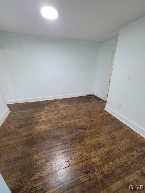 unfurnished room with dark wood-type flooring