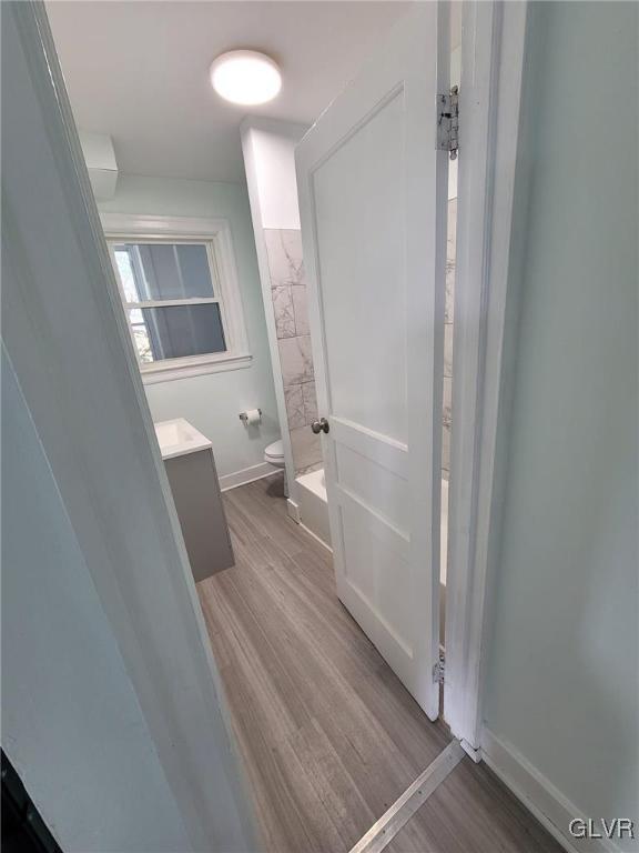 full bathroom with toilet, vanity, tub / shower combination, and hardwood / wood-style flooring