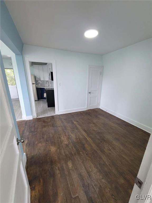 unfurnished room with dark hardwood / wood-style floors