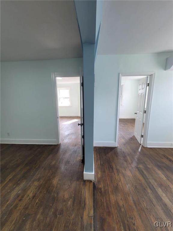 unfurnished room with dark wood-type flooring