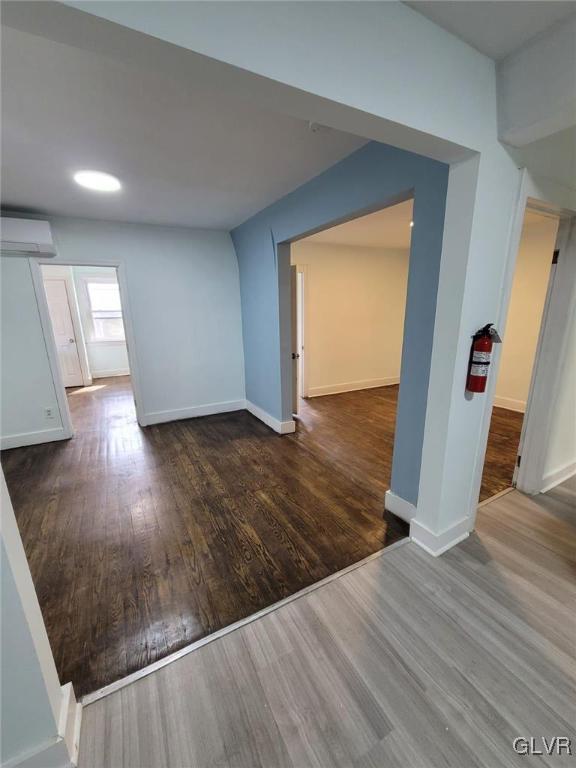 spare room featuring dark hardwood / wood-style flooring and a wall mounted AC