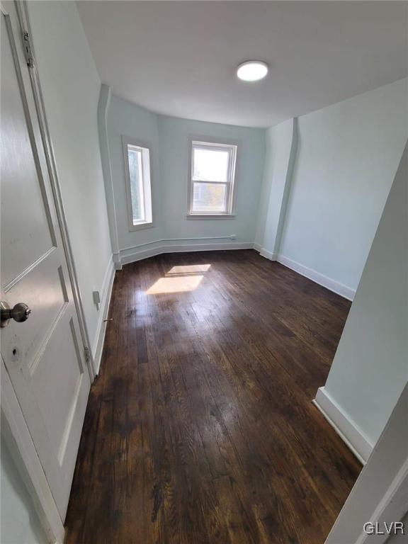 unfurnished room with dark hardwood / wood-style flooring