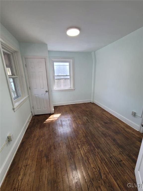 unfurnished room with dark hardwood / wood-style flooring