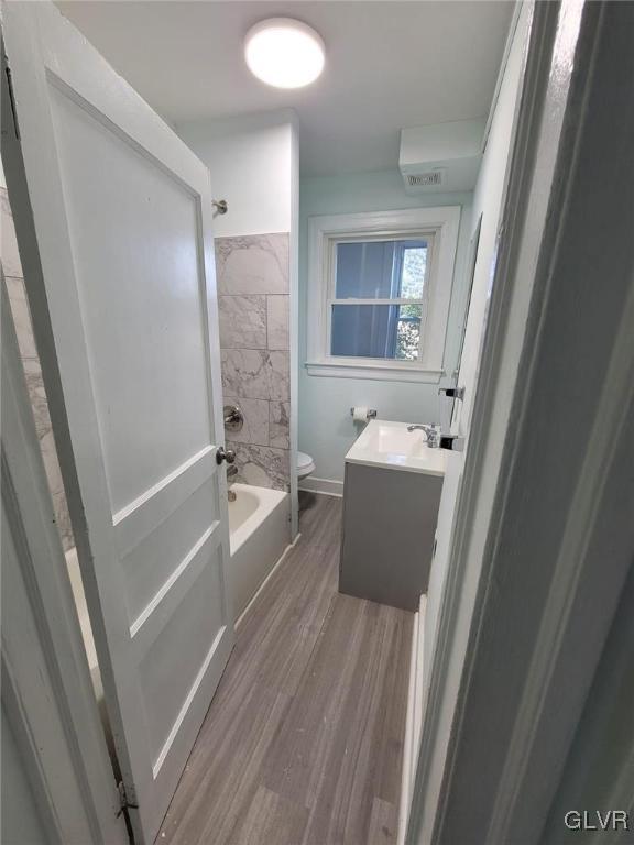 full bathroom featuring toilet, vanity, shower / washtub combination, and hardwood / wood-style floors