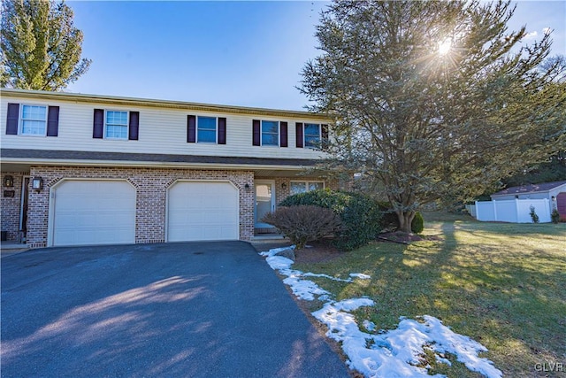 view of front of property with a garage and a lawn