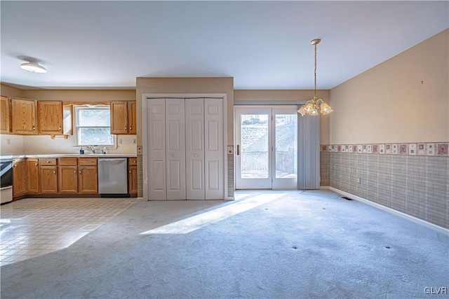 kitchen featuring light colored carpet, pendant lighting, dishwasher, and a notable chandelier