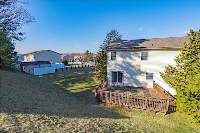 back of house featuring a wooden deck and a lawn